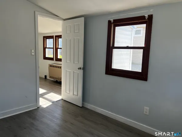an empty room with wooden floor and a window