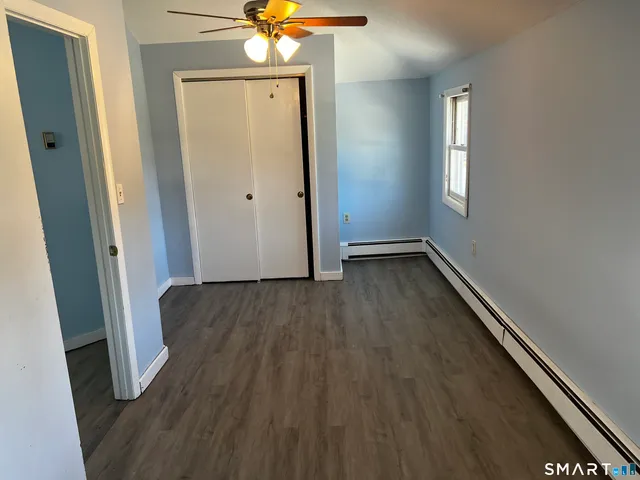 an empty room with wooden floor and hallway