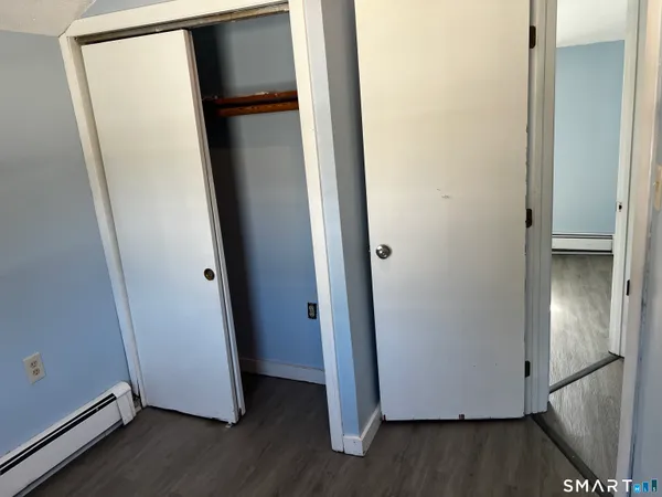 a view of walk in closet with wooden floor