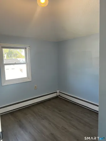 a view of a room with wooden floor and window