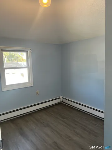a view of a room with wooden floor and window