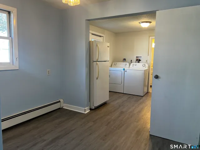 an empty room with wooden floor and white walls