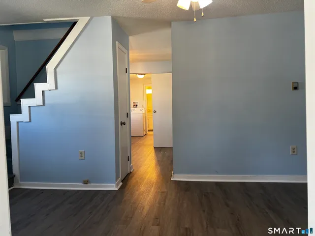 a view of a hallway with wooden floor and staircase