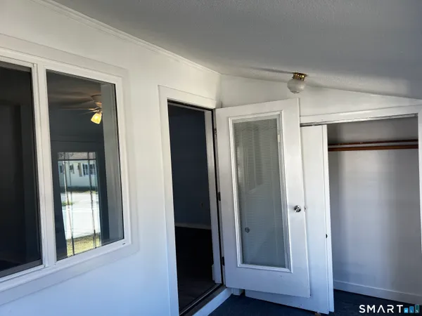 a view of an empty room with closet and wooden floor