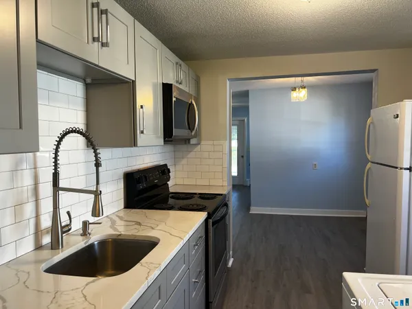 a kitchen with a sink a refrigerator and cabinets