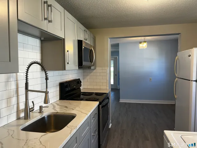 a kitchen with a sink a refrigerator and cabinets