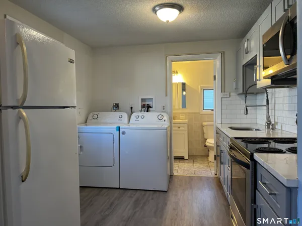 a kitchen with a sink a refrigerator a stove and wooden floor