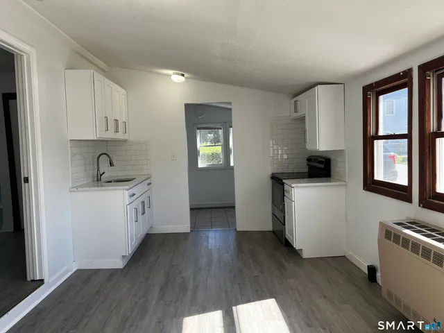 a kitchen with a refrigerator and a stove top oven