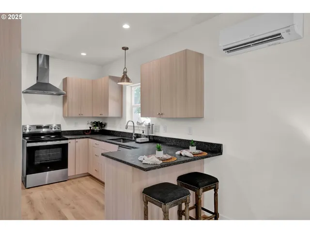 a kitchen with stainless steel appliances granite countertop a stove a sink and a refrigerator