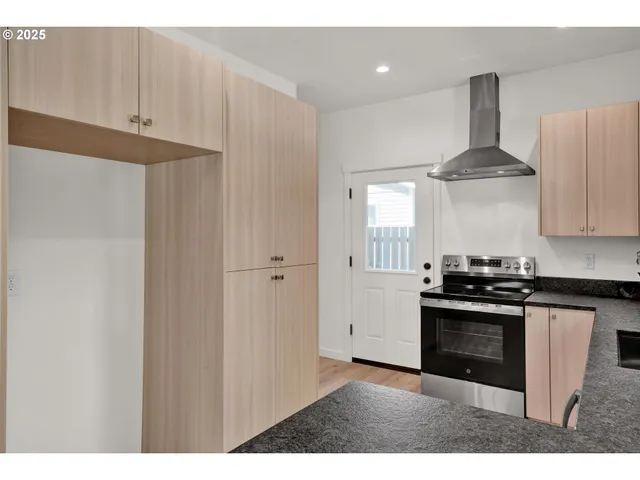 a kitchen with stainless steel appliances a stove and white cabinets