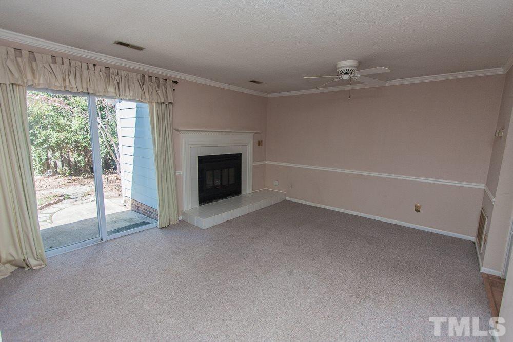 1535 Edgeside Court Raleigh, NC 27609 - Photo 4 of 20 a view of an empty room with a fireplace and a window