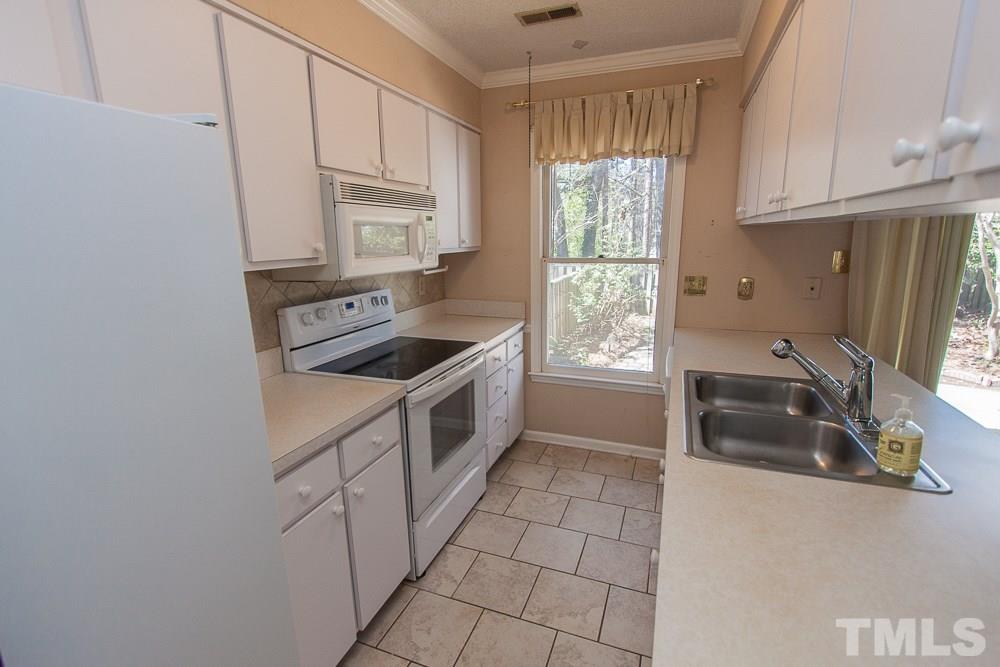 1535 Edgeside Court Raleigh, NC 27609 - Photo 5 of 20 a kitchen with granite countertop a sink a stove a refrigerator and cabinets