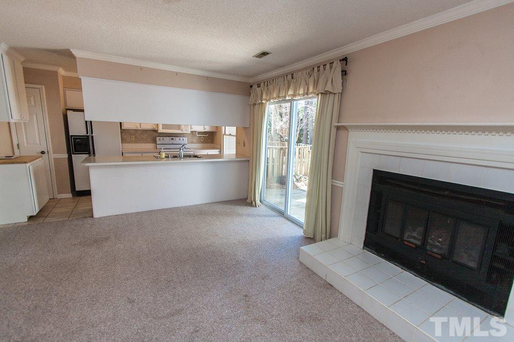 1535 Edgeside Court Raleigh, NC 27609 - Photo 6 of 20 a living room with stainless steel appliances white cabinets and a fireplace