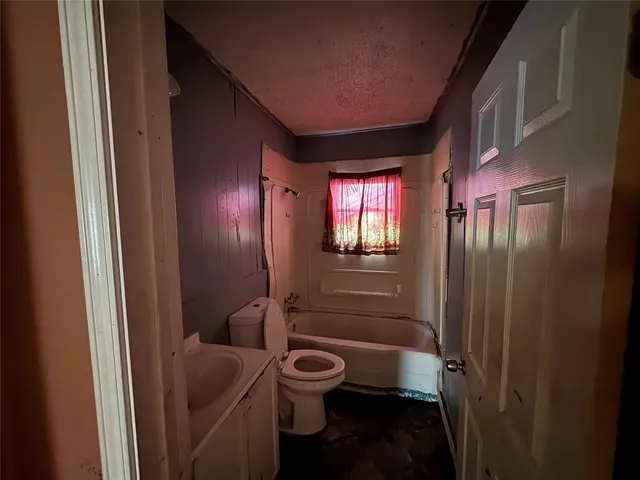 a bathroom with a toilet a sink and shower curtain