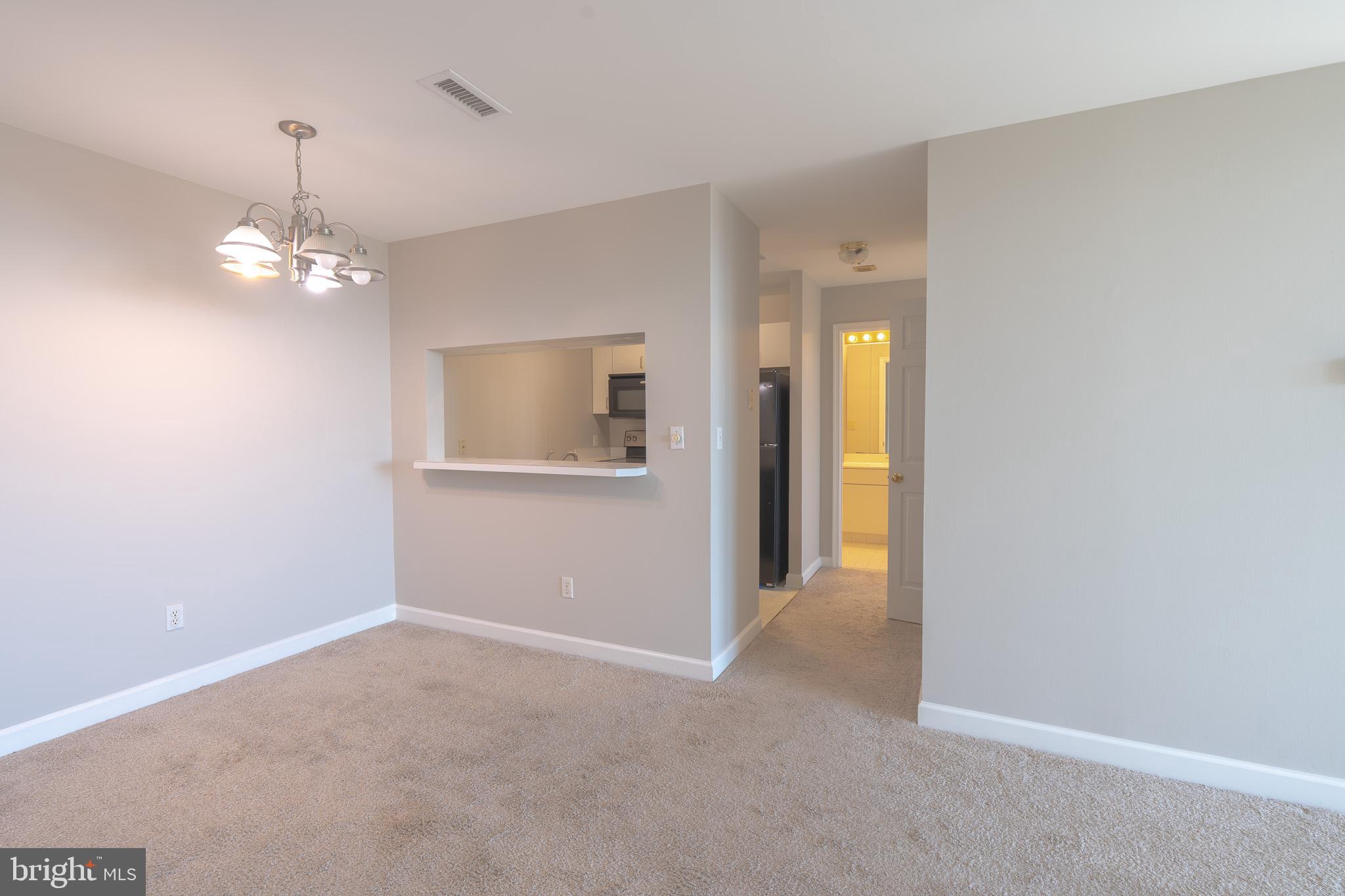 100 Harborview Drive, Unit 1208 Baltimore, MD 21230 - Photo 13 of 36 a view of a hallway with wooden floor and a chandelier