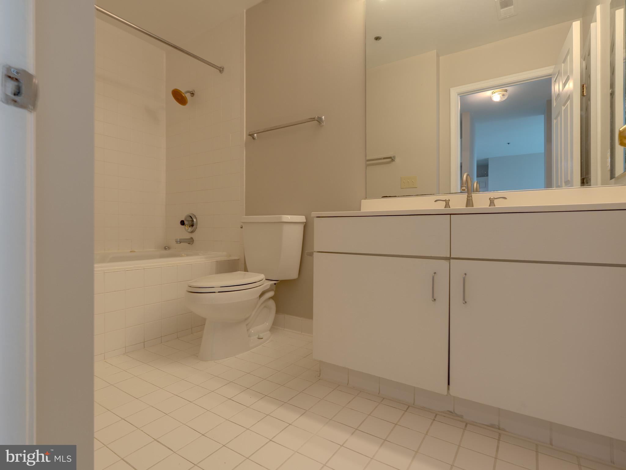 100 Harborview Drive, Unit 1208 Baltimore, MD 21230 - Photo 29 of 36 a bathroom with a toilet sink and mirror