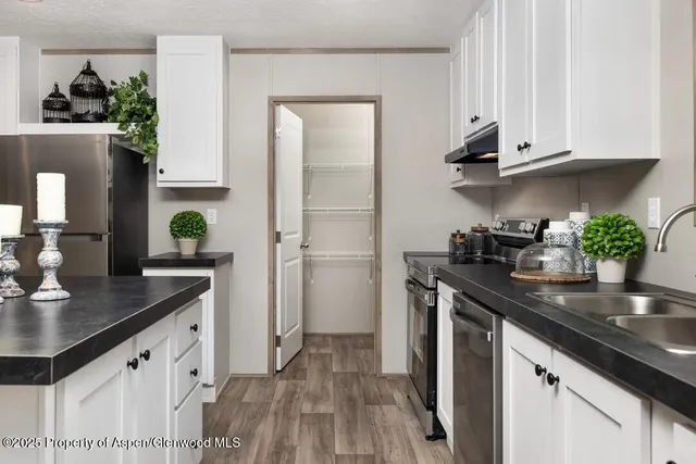 a kitchen with stainless steel appliances granite countertop a sink and cabinets