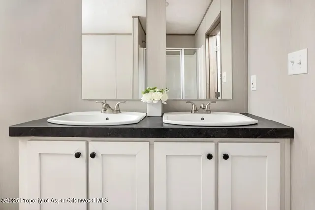 a bathroom with double sink and a mirror