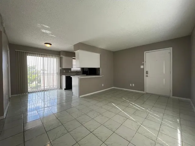 a view of a kitchen with wooden floor and a refrigerator