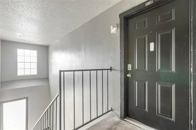 a view of staircase with railing and a chandelier