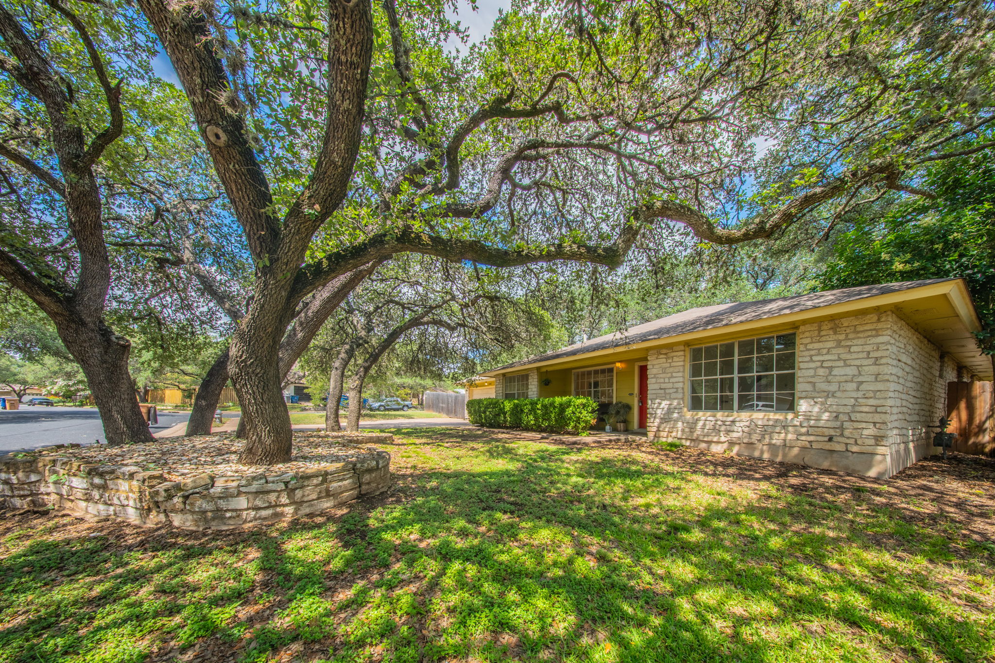 4504 Langtry Lane Austin, TX 78749 - Photo 4 of 24 Mature trees shade this home's rock facade, enhancing its curb appeal.