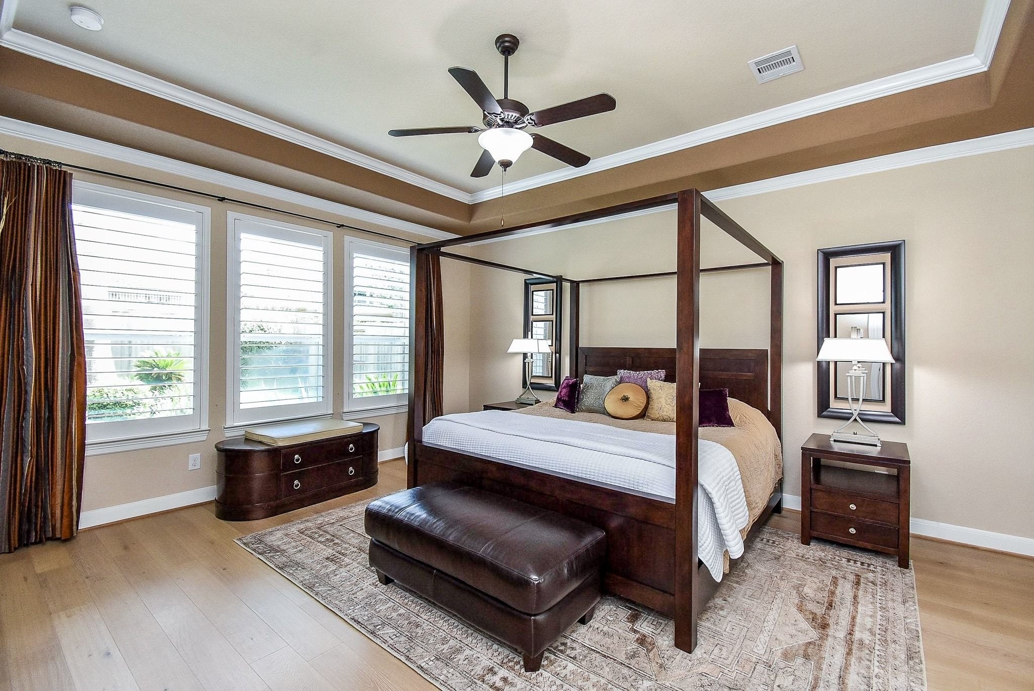 27607 Macklind Ridge Lane Katy, TX 77494 - Photo 28 of 50 Primary bedroom down with coffered ceilings with crown molding, plantation shutter, tons of windows, ceiling fan and engineered wood floors.
