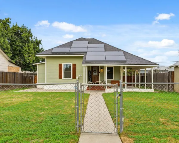 a view of a house with a yard and sitting area