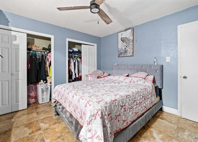 a bedroom with a large bed and a chandelier