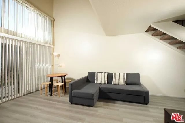 a living room with furniture and a floor to ceiling window