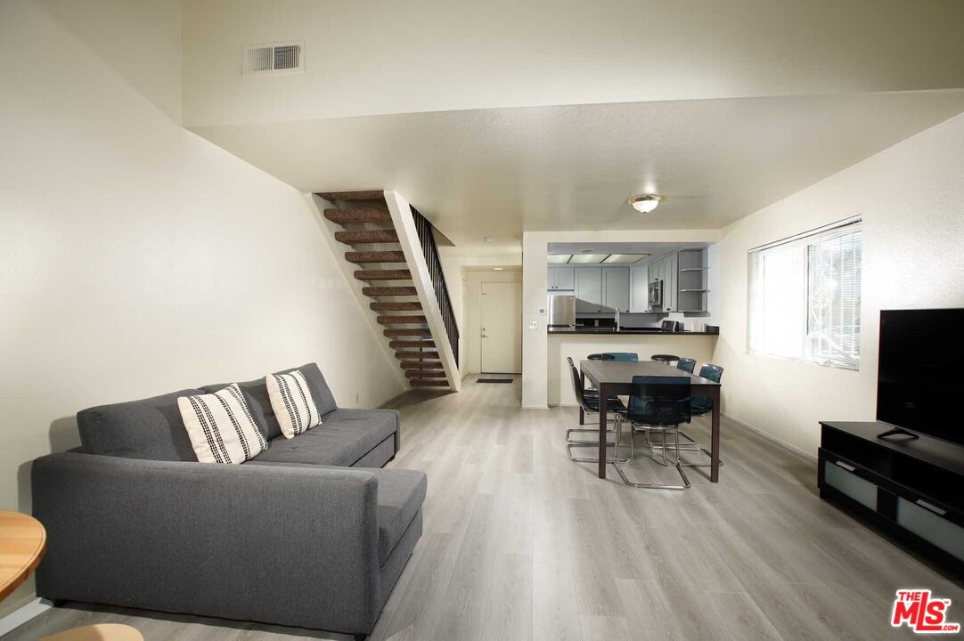 936 East Fairway Drive, Unit 23 Colton, CA 92324 - Photo 4 of 32 a living room with furniture and a flat screen tv with kitchen view