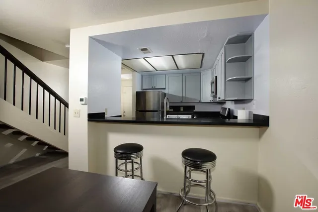 a kitchen with stainless steel appliances granite countertop a refrigerator a stove a sink dishwasher and a stove with wooden floor