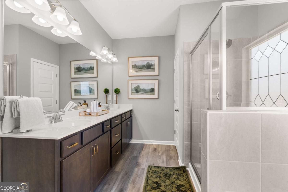 10429 Trellis Lane, Unit (LOT 29) Hampton, GA 30228 - Photo 18 of 27 a bathroom with a sink a mirror and a window