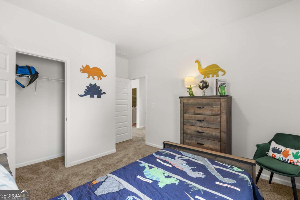 10429 Trellis Lane, Unit (LOT 29) Hampton, GA 30228 - Photo 25 of 27 a room with toys and dresser with wooden floor