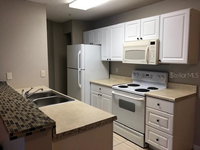 957 Salt Pond Place, Unit 101 Altamonte Springs, FL 32714 - Photo 8 of 20 a kitchen with a stove a sink and a refrigerator