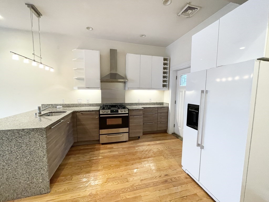 98 L Street, Unit STREET Boston, MA 02127 - Photo 1 of 19 a large kitchen with stainless steel appliances and a sink