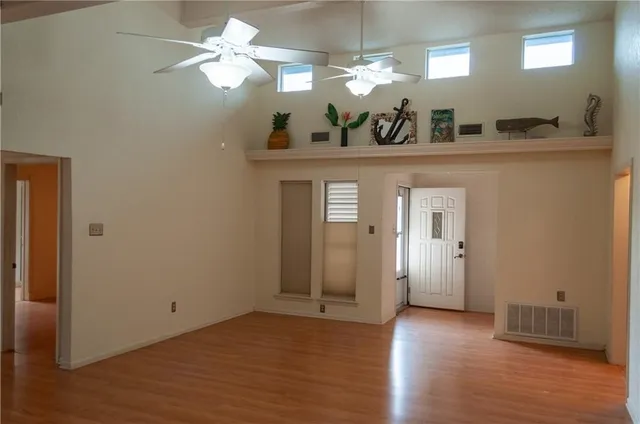 a view of a room with a chandelier and wooden floor