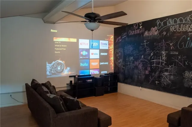 a living room with furniture a window and wooden floor