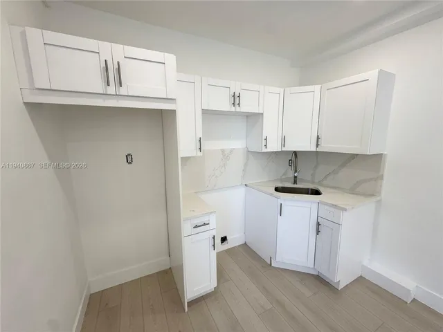 a kitchen with a sink cabinets and wooden floor
