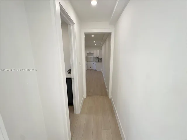 a view of a hallway with closet and wooden floor