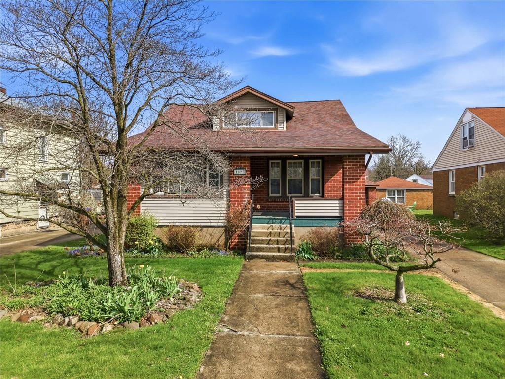 a front view of a house with a garden and plants
