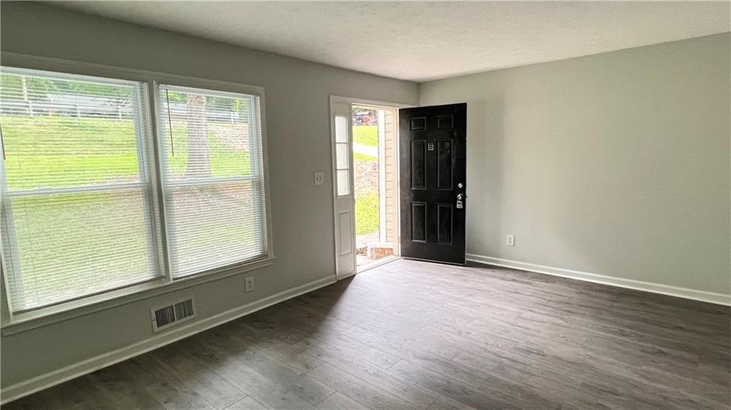 4007 Burns Road Northwest Lilburn, GA 30047 - Photo 6 of 20 a view of an empty room with wooden floor and a window