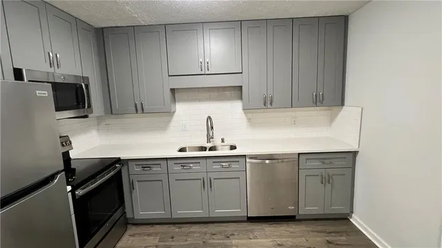 a kitchen with stainless steel appliances a sink stove and cabinets