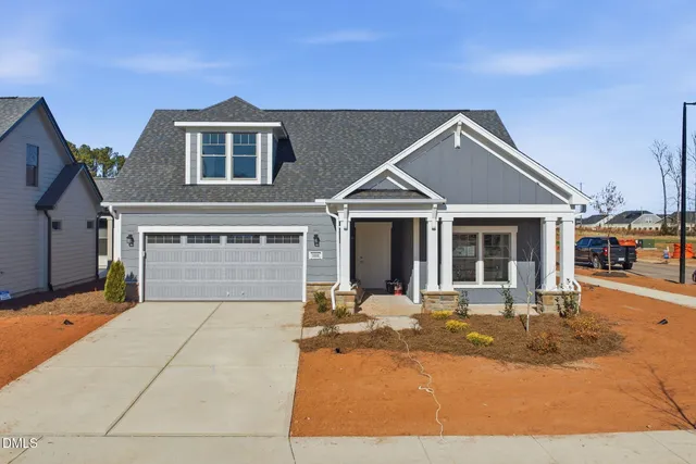 a front view of a house with a yard outdoor seating and garage