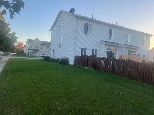 a view of a house with a yard and pathway