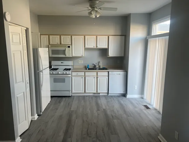 a kitchen with stainless steel appliances a sink cabinets and wooden floor