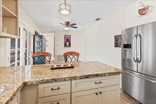 a kitchen with stainless steel appliances granite countertop a sink and a refrigerator