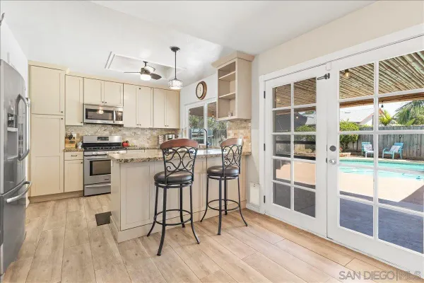 a kitchen with stainless steel appliances a stove a sink dishwasher a refrigerator and cabinets with wooden floor