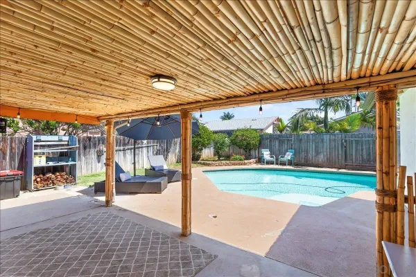 a view of a patio with a table and chairs under an umbrella