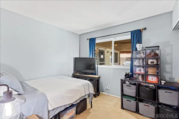 a bedroom with a bed and a flat tv screen