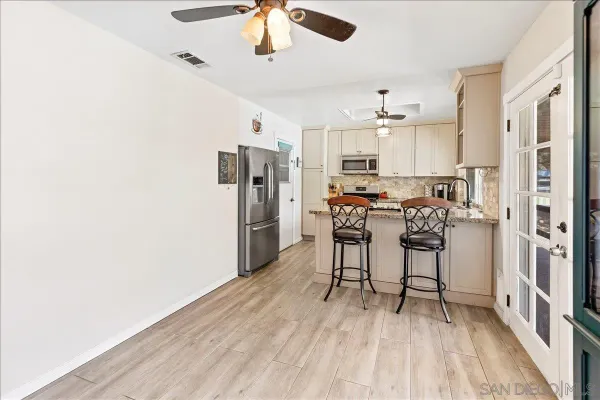 a view of a kitchen with stainless steel appliances refrigerator stove and wooden floor